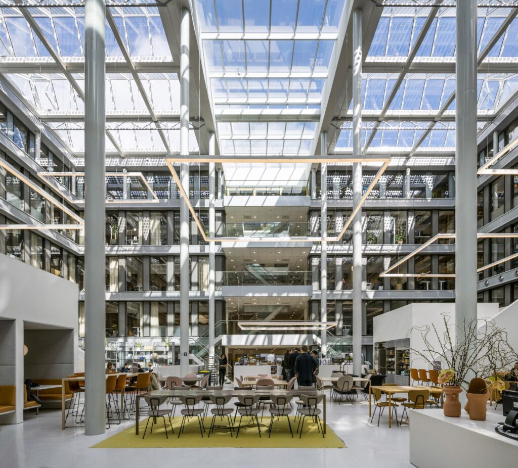 Modern, sunlit atrium of an office building on Mr. Treublaan with open workspaces and seating areas.